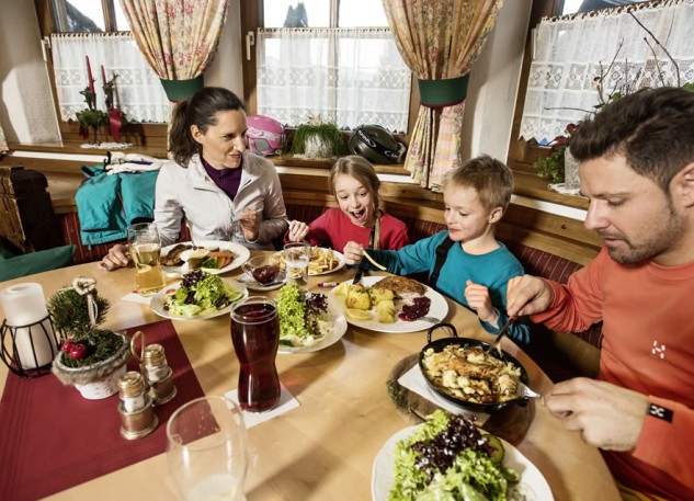 Familie beim Essen in einer der urigen Skihütte © Flachau Tourismus